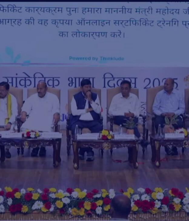 Thinklude live captions in Hindi displayed above the stage at a Sign Language Day 2025 event.